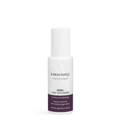 REBEL hair texturiser in a white Karmameju spray bottle with cap on and a plum label, on white