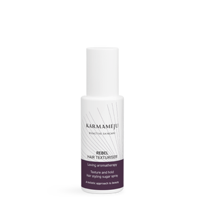 REBEL hair texturiser in a white Karmameju spray bottle with cap on and a plum label, on white